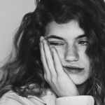 sad woman touching cheek in studio