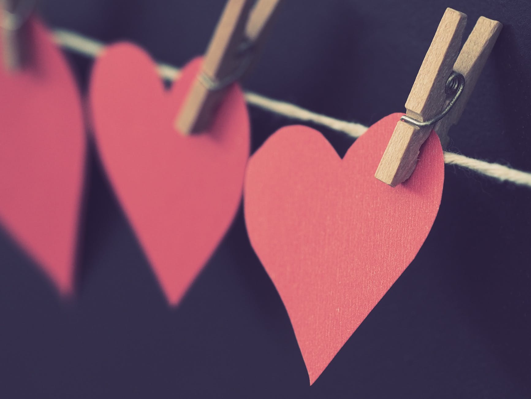 photo of red heart shaped paper hanging on rope