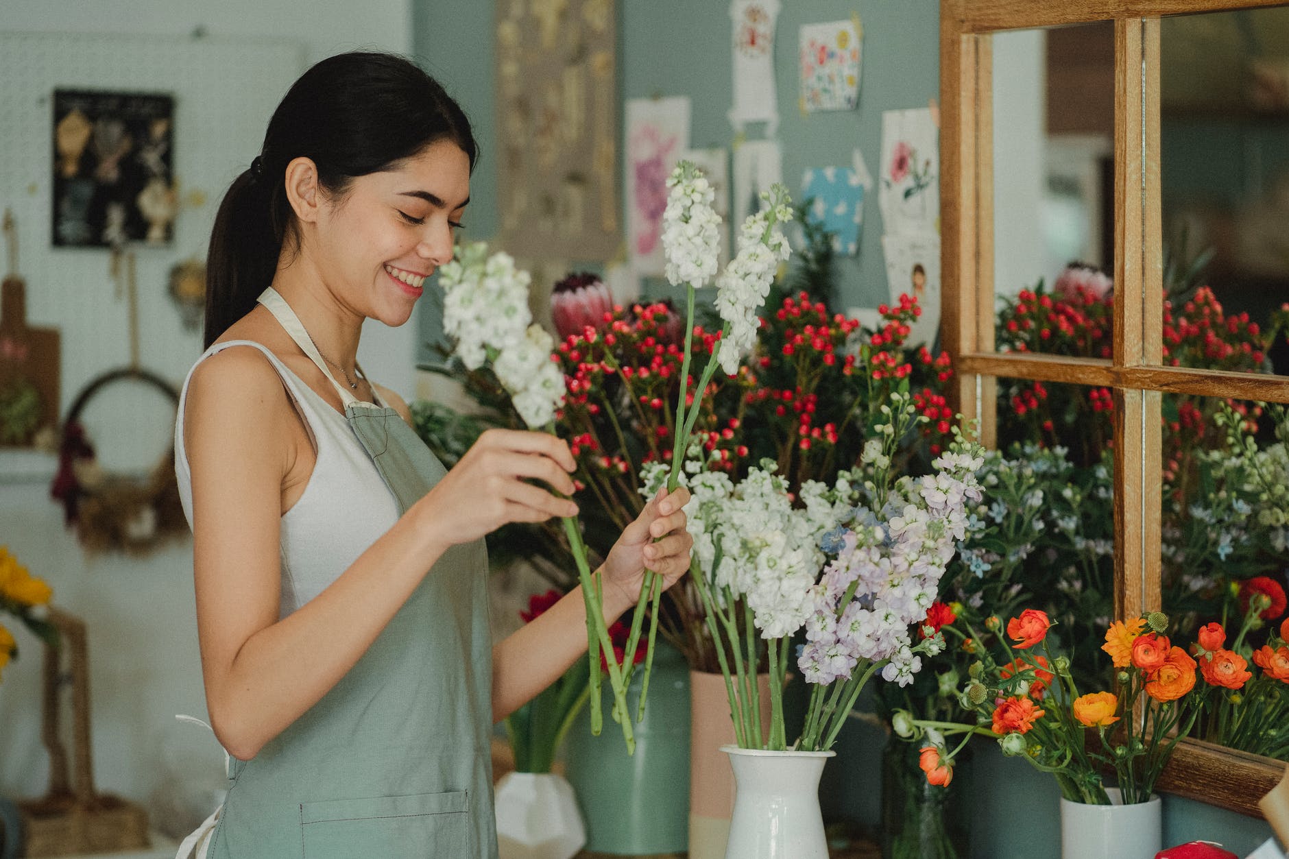 cheerful florist choosing flowers in shop