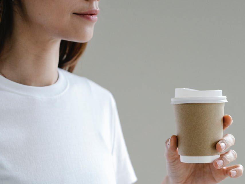 female enjoying coffee to go in paper cup