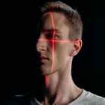 close up photo of man with laser lines on his face