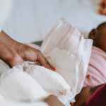black mother changing diaper for baby