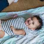 adorable baby lying on comforter