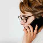 thoughtful adult woman talking on smartphone