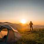 silhouette of person standing near camping tent