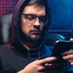 a man in black hoodie sweater using his mobile phone