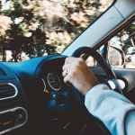 person holding black vehicle steering wheel