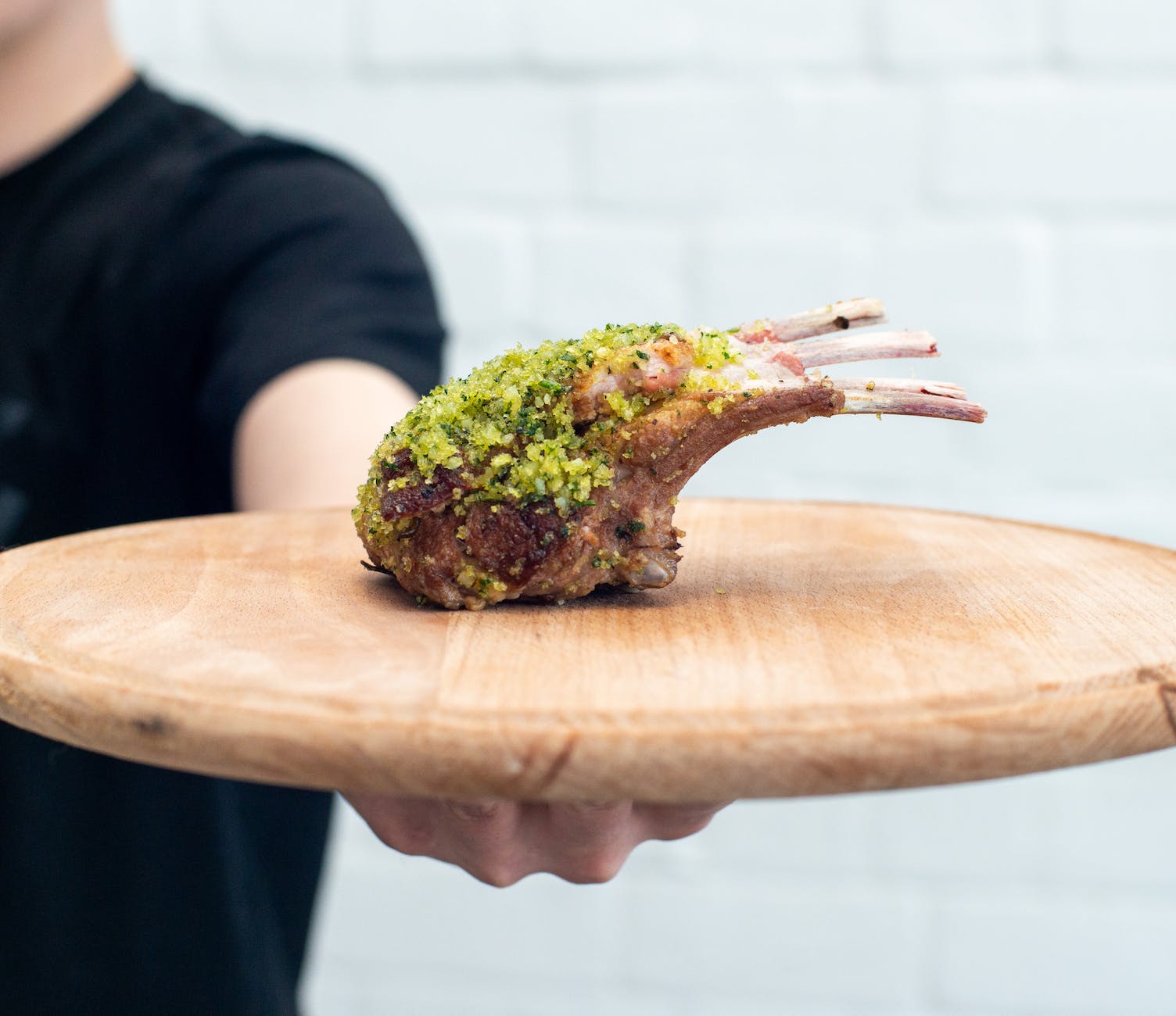 man holding meat on cutting board