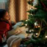 girl in red sweater lying down on pillows
