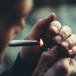 selective focus photography of man lighting cigarette