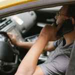 focused driver speaking on smartphone in car