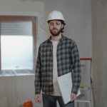 man in white and black plaid dress shirt holding white printer paper