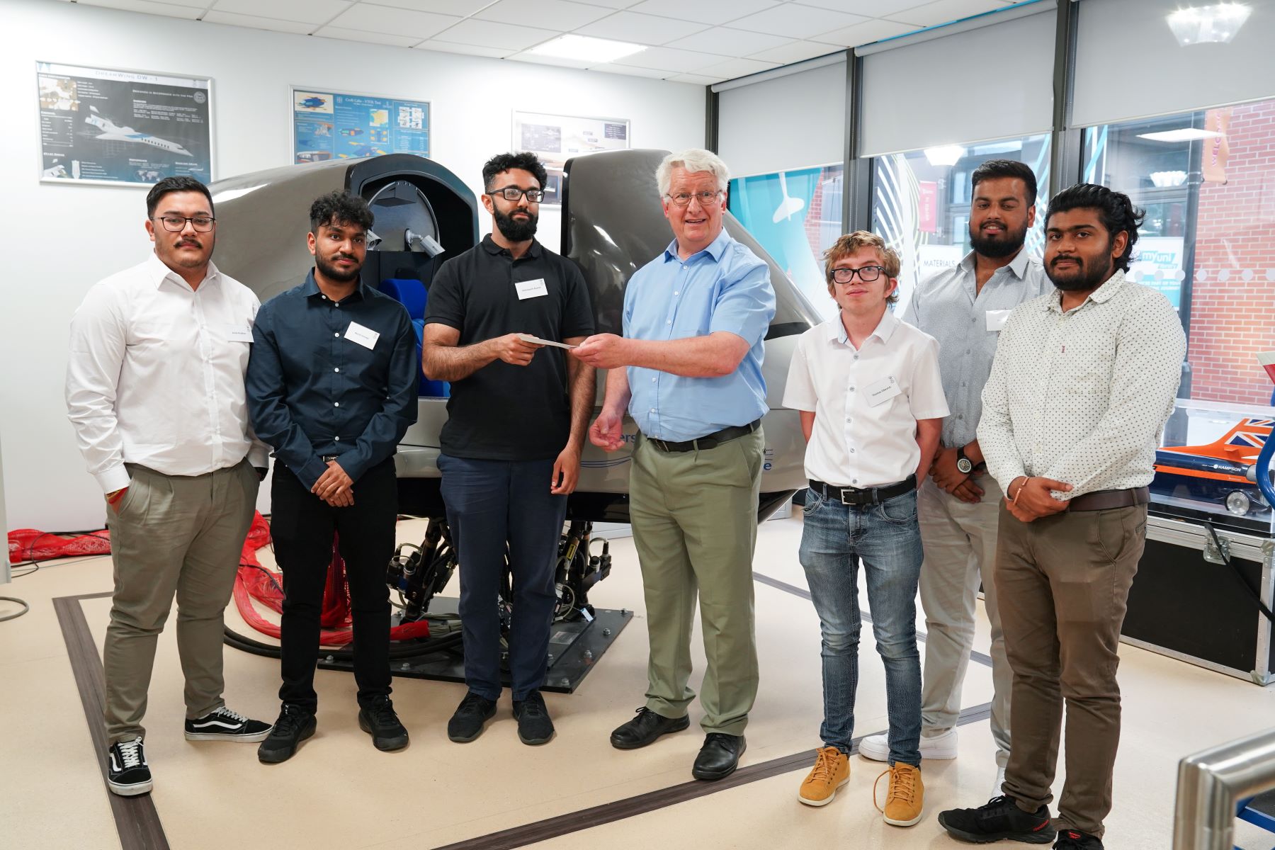 Chris Neale, from Merlin Flight Simulation Group, presents the first prize of £500 to the winning Swansea University team