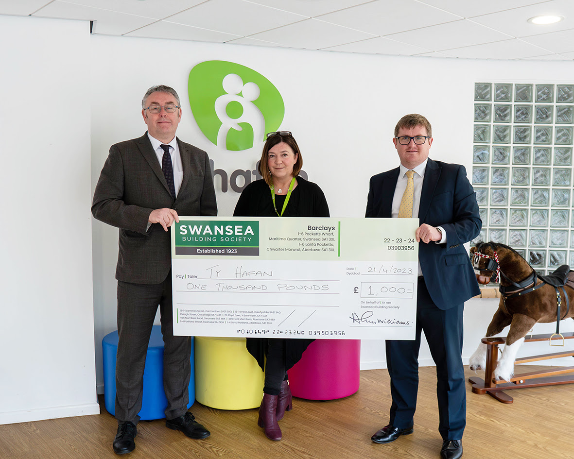 Richard Miles (left) and David Osterland (right) of Swansea Building Society hand over cheque for £1,000 to Sorrel Mayo (centre) of Tŷ Hafan Children's Hospice