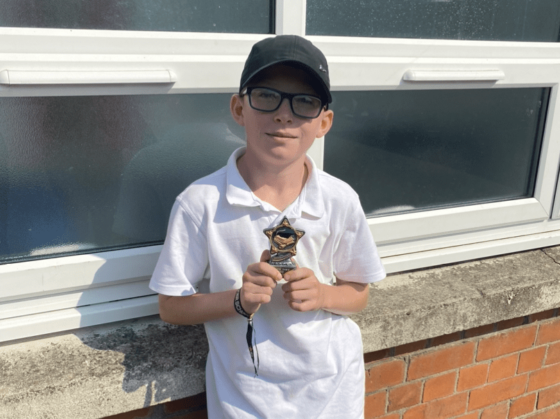 Carter holding an award for Sports Player of The Year last year at school