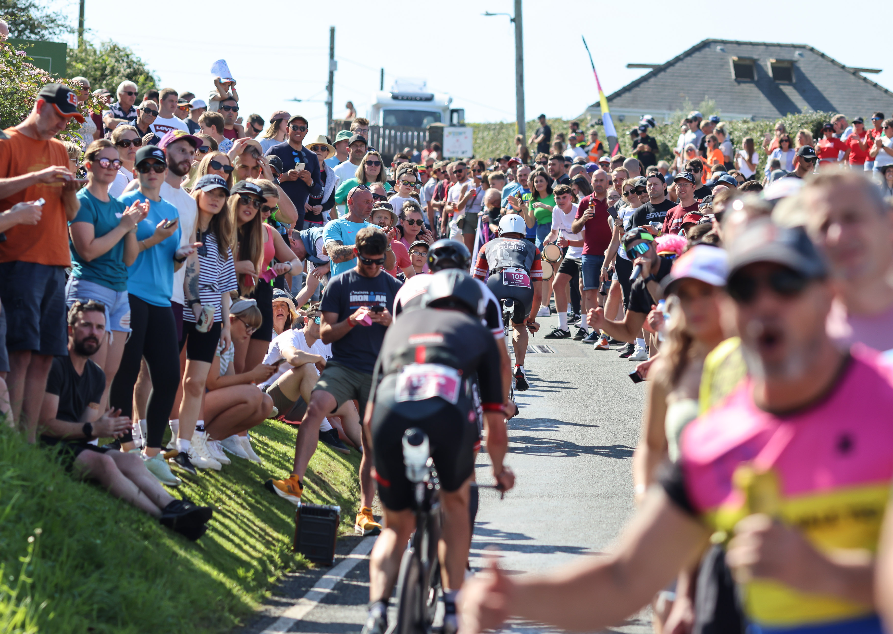 Athletes surrounded by spectators on the cycle element of the route