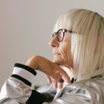 pensive elderly woman in eyeglasses and trendy bomber