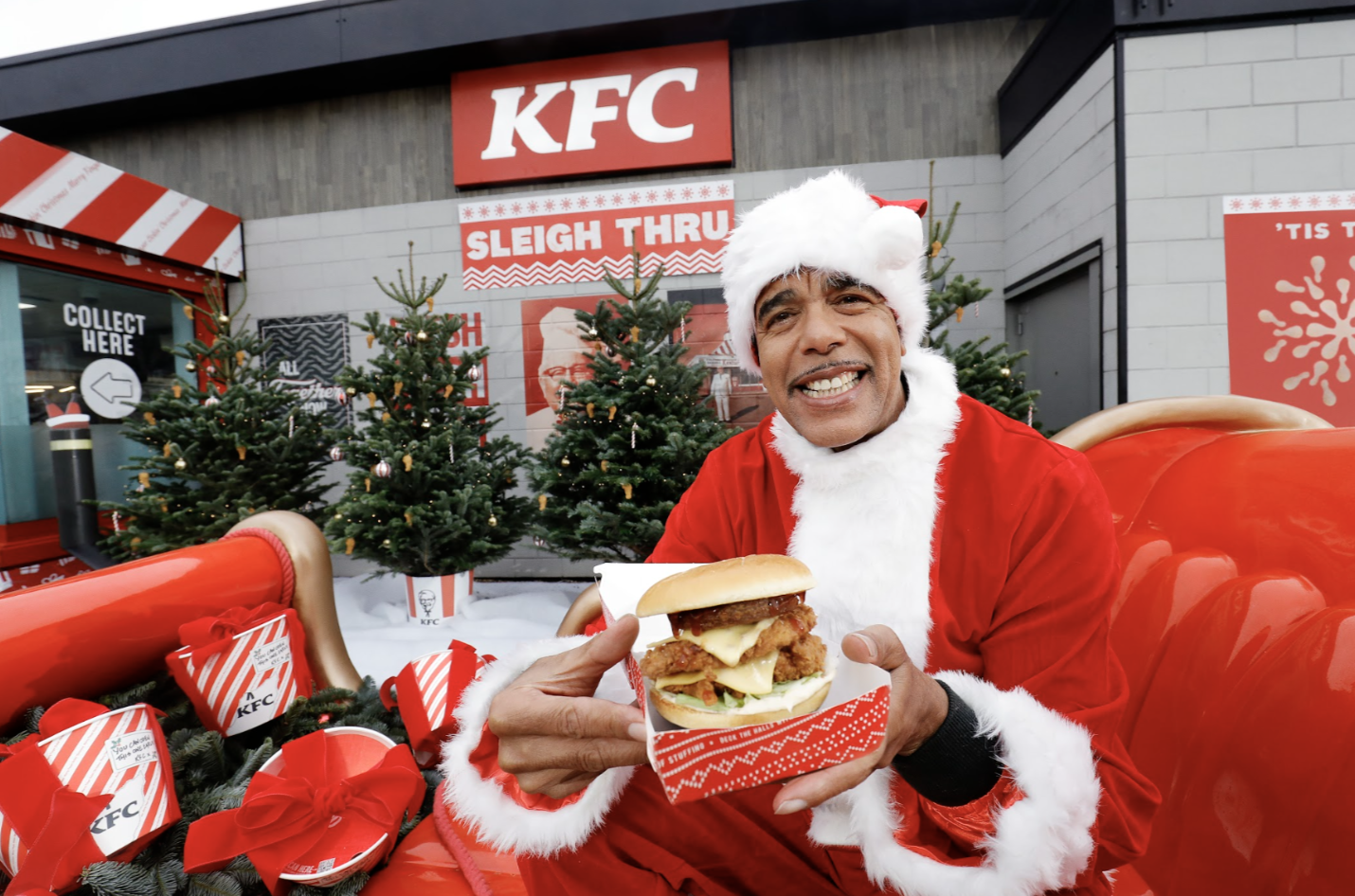 Chris Kamara enjoying a free stuffing stacker burger at a KFC Sleigh Thru!