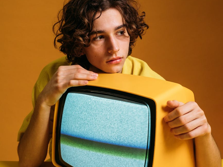 handsome guy holding a yellow tv