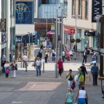 Shoppers walking through St Catherine's Walk shopping centre in Carmarthen High Street with River Island and Next stores visible