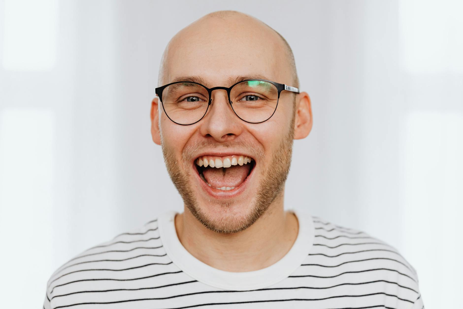 man with black framed eyeglasses laughing