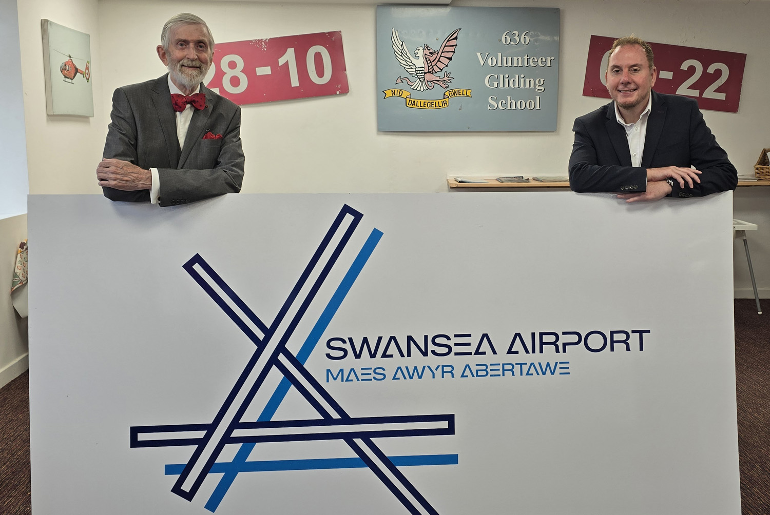 Swansea Council leader Rob Stewart, right, and Swansea Airport Stakeholders’ Alliance chairman Bob Oliver at the airport with one of its new signs. Pic: Swansea Council