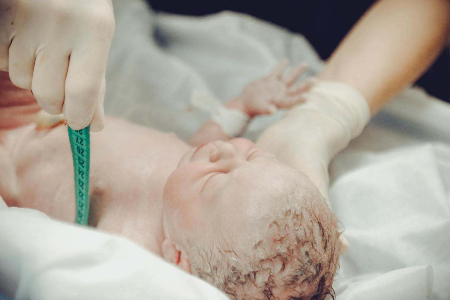 health personnel measuring a newborn baby