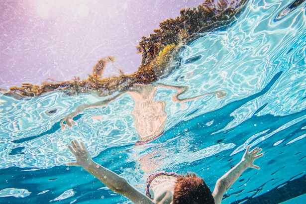 man in blue shorts swimming in water
