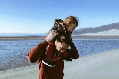 a father carrying his child on his shoulders