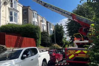 Firefighters from Morriston Fire Station used a specialist turntable ladder — and cat treats — to rescue a feline stranded on a three-storey rooftop in Brynmill, Swansea