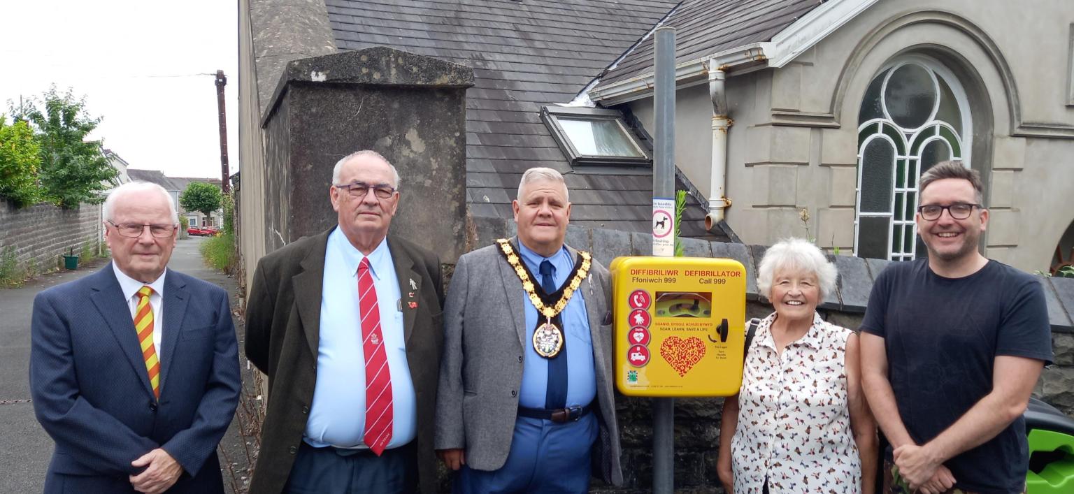 Bigyn Ward councillors Michael Cranham , Alan Williams, Janet Williams and David Darkin with Llanelli town mayor Andrew Bragoli with the new defibrillator at Glenalla Hall.