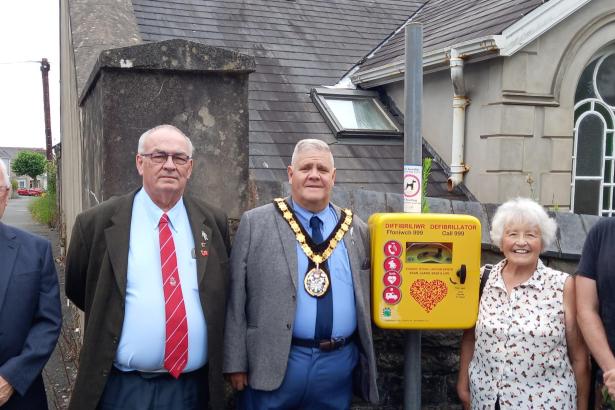 Bigyn Ward councillors Michael Cranham , Alan Williams, Janet Williams and David Darkin with Llanelli town mayor Andrew Bragoli with the new defibrillator at Glenalla Hall.