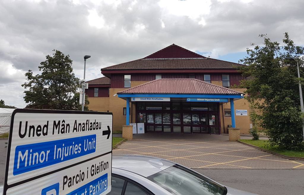 The Minor Injuries Unit entrance at Prince Philip Hospital in Llanelli, with the bilingual Uned Man Anafiadau road sign in the foreground