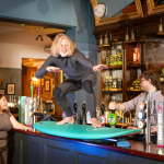 Owen from Surf Therapy, one of the grassroots sports clubs supported by the Greene King IPA Proud To Pitch In campaign, stands on a surfboard on the bar at the Wig and Pen pub in Oxford. (Richard Dawson/PA Media Assignments)