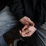 person in black jacket and gray denim jeans