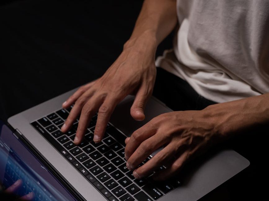 person in white long sleeve shirt using macbook pro