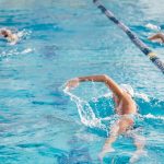 man swimming on an indoor swimming pool