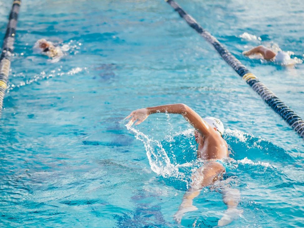 man swimming on an indoor swimming pool