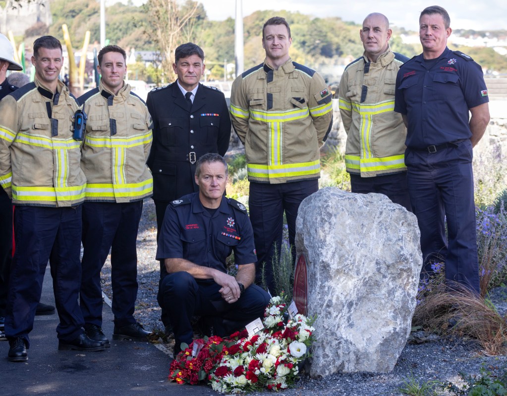 Firefighters place a ceremonial wreath at Alan Sherratt’s Red Plaque memorial in Swansea, commemorating his legacy.