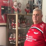 Llanelli mayor Andrew Bragoli stands in a Scarlets shirt in front of his memorabilia collection, showing his support for the Save Our Scarlets campaign.