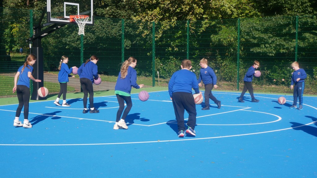 Children playing basketball on the newly opened court at Maesteg Welfare Park, part of Bridgend’s £82,500 investment in accessible multi-sport infrastructure.