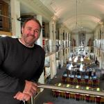 Rugby legend Scott Quinnell stands on a balcony inside the National Library of Wales during filming of S4C’s Cyfrinachau’r Llyfrgell.