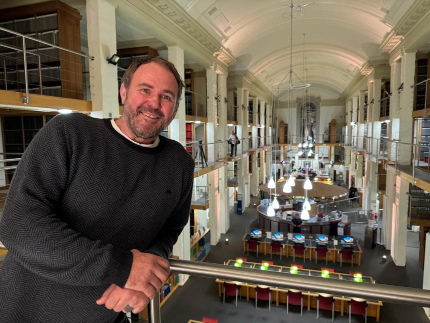 Rugby legend Scott Quinnell stands on a balcony inside the National Library of Wales during filming of S4C’s Cyfrinachau’r Llyfrgell.