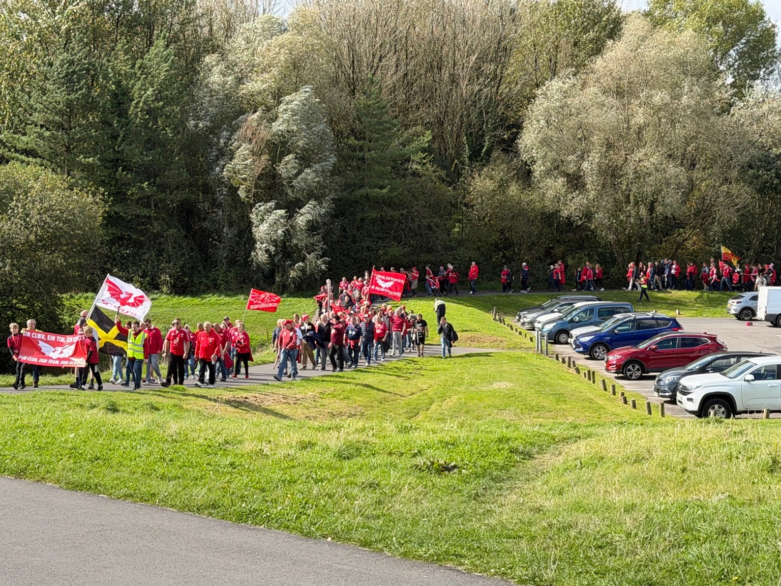 Scarlets fans snake along the path next to Sandy Water Park's car park