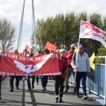 The protestors march across Pont d'Agen bridge crossing the coastal road