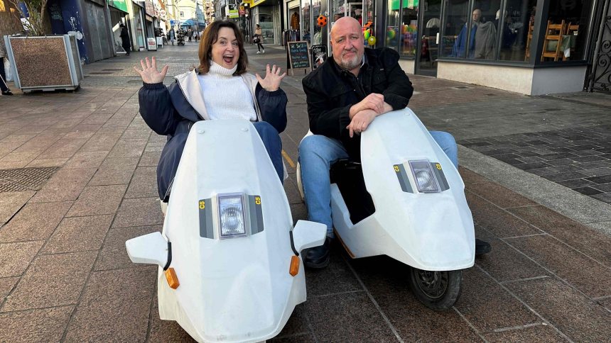 Actors Ruth Jones and Steve Speirs riding Sinclair C5s during filming for BBC Cymru Wales’ From Porthcawl with Love, a nostalgic look at Jones’ hometown of Porthcawl.