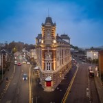 Aerial night view of the renovated Palace Theatre in Swansea, lit up along High Street after restoration.