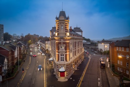 Aerial night view of the renovated Palace Theatre in Swansea, lit up along High Street after restoration.