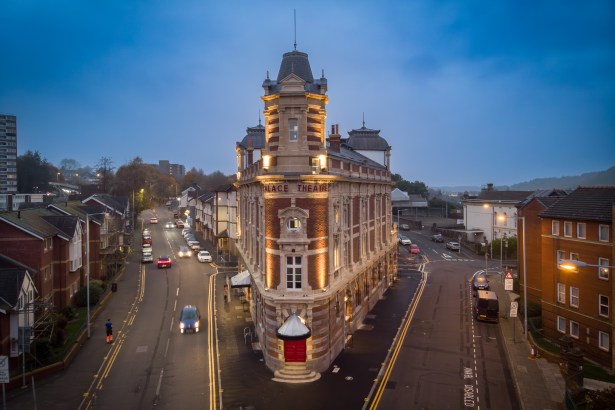 Aerial night view of the renovated Palace Theatre in Swansea, lit up along High Street after restoration.