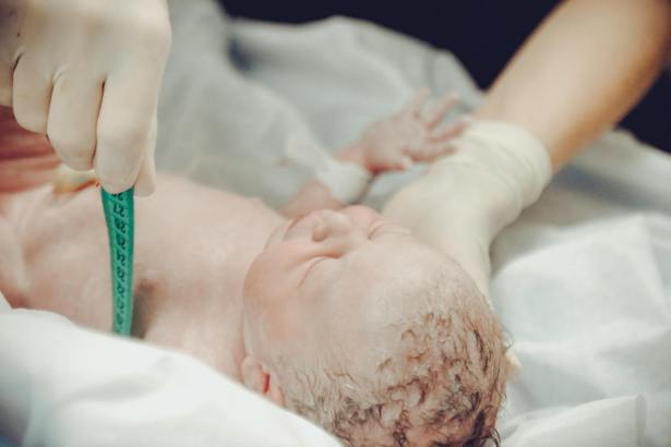 health personnel measuring a newborn baby